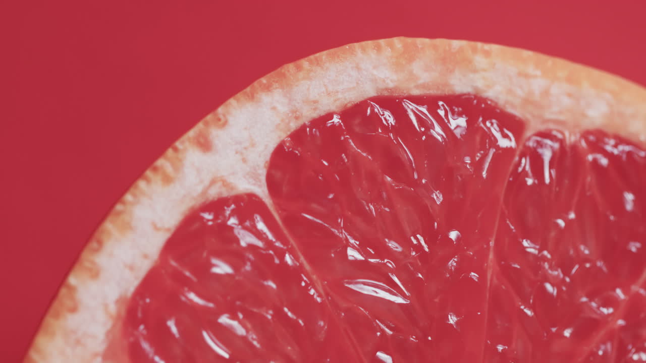 video de pomelo rojo en rodajas con espacio de copia sobre fondo rojo