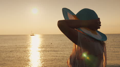 una mujer con un sombrero espera el amanecer sobre el concepto de vacaciones y vacaciones en el mar