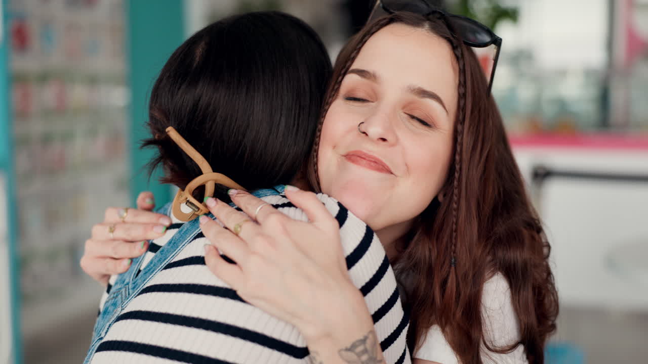 amigos, sonríe y las mujeres se abrazan en el café