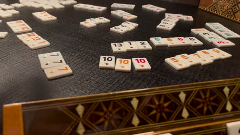 mano de mujer jugando al juego de mesa rummikub en la mesa