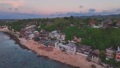 Panning-drone-clip-of-cliffside-village-of-Bingin,-Bali,-Indonesia---a-popular-tourism-vacation-destination-for-surfing,-snorkeling-and-diving