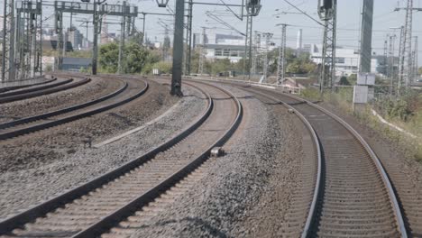 railroad tracks curve ahead offering a dynamic view from the train cockpit, showcasing the urban landscape