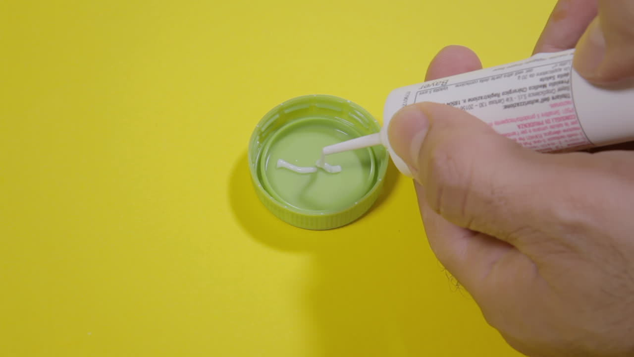 preparando un cebo con un potente gel venenoso, usando una tapa de botella verde