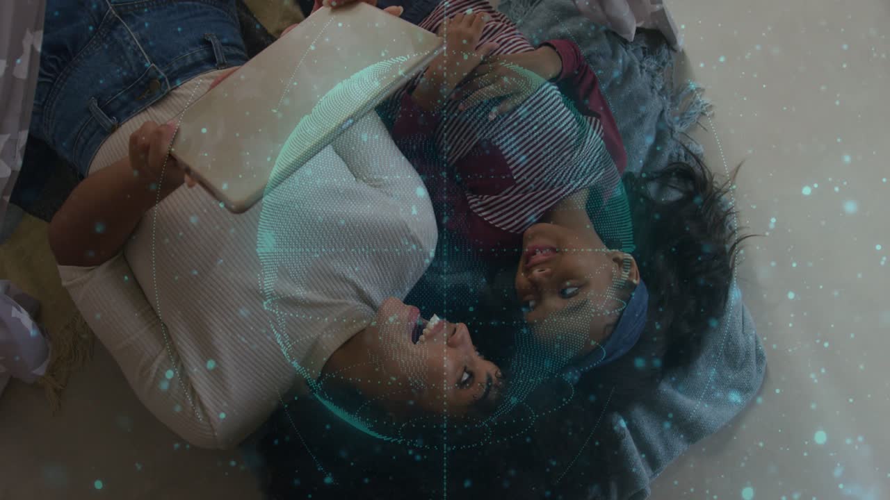 Adult woman holding tablet and tilting sharing screen causing teal tech particles swirling over kid