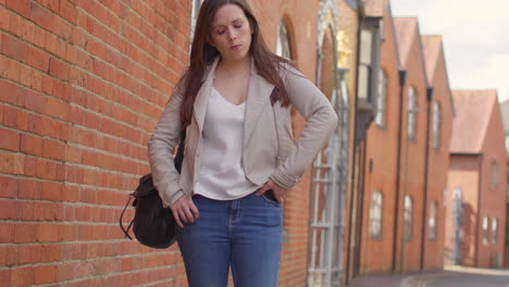 Stressed-And-Worried-Woman-Outdoors-With-Financial-Worries-About-Cost-Of-Living-Crisis-Debt-And-Paying-Bills-Looking-At-Mobile-Phone-On-City-Street-2