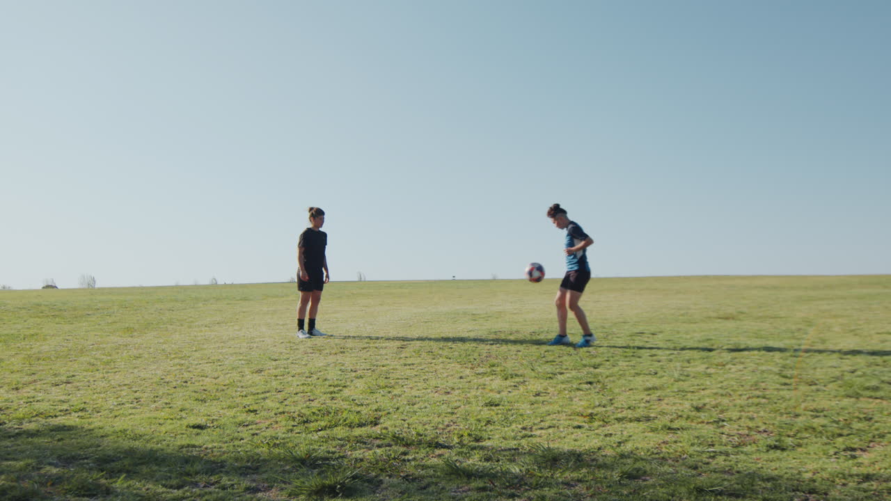 Wide Shot of Soccer Girls Training Kick-Ups on Green Field