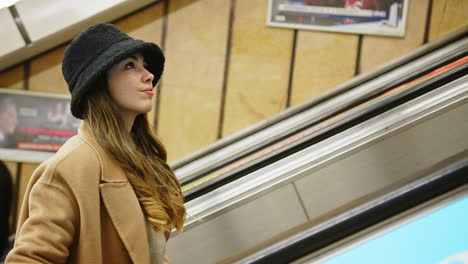 young woman going up the escalators of a subway station