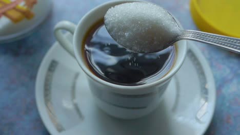 vertiendo azúcar en una taza de café