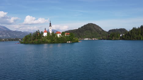 wide aerial shot of lake bled and a lone man on a kayak