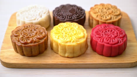 colourful chinese moon cake with mixed flavour on wood plate