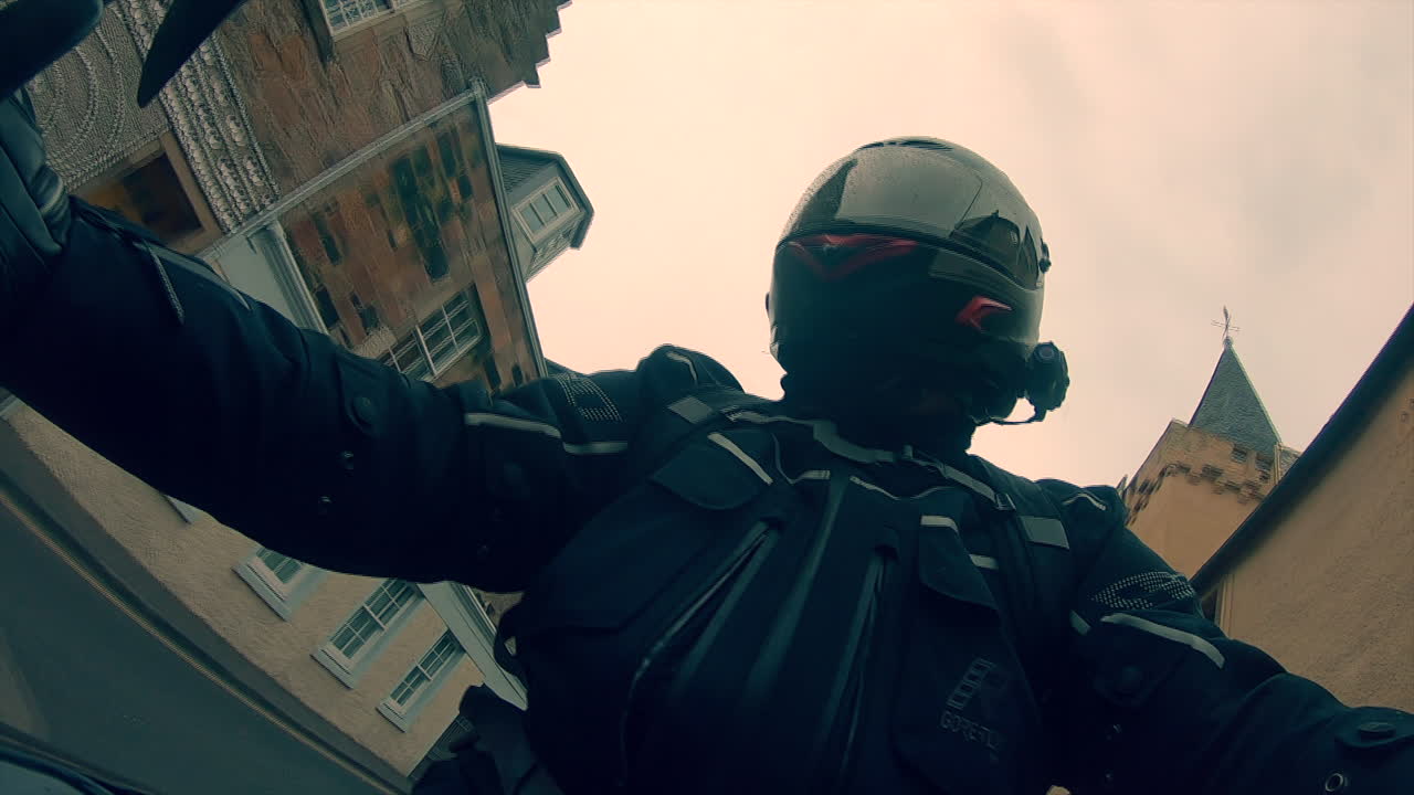 Biker selfie video riding a motorcycle through towns and villages in Scotland on a rainy day