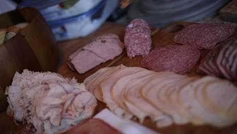 shot slowly panning over a platter of different variety of meats including turkey, ham, and salami