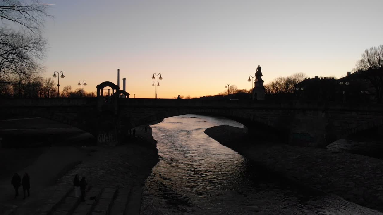 vista de la puesta de sol de un puente sobre el río isar munich alemania