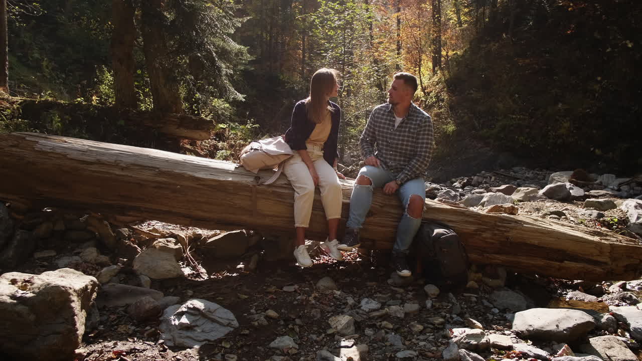 한 커플 이 숲 에서 경치 좋은 가을 산책 을 즐기고 있다