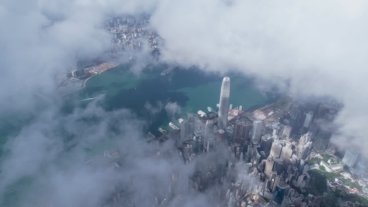 Epic aerial view of the Victoria Harbour in a clear day, with thick cloud and sunlight