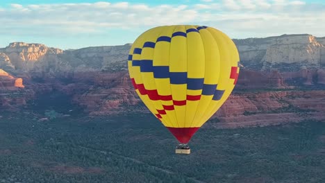 hot air balloon flying over idyllic landscape of sedona in arizona, usa - drone shot