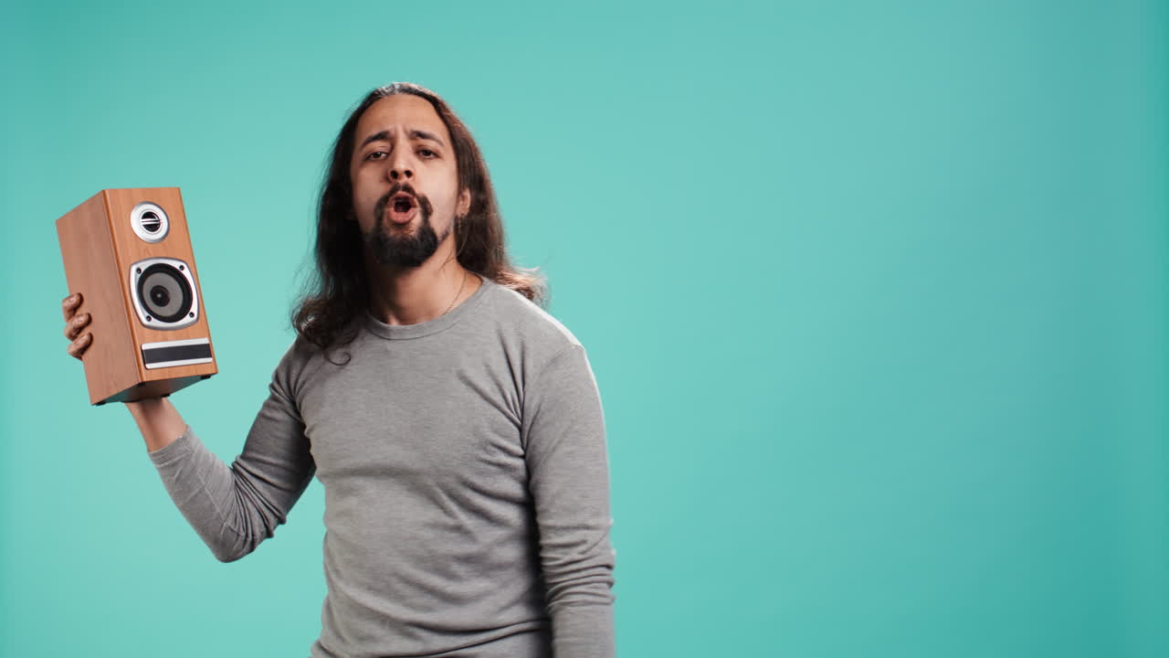 retrato de una persona divirtiéndose sosteniendo altavoces, escuchando música