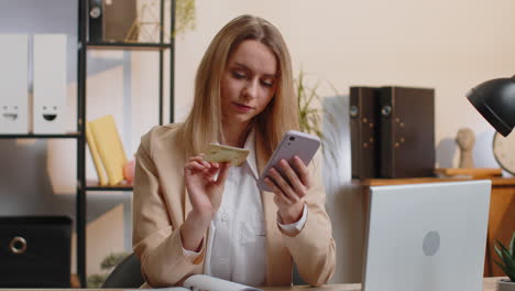 businesswoman making online purchase payment shopping with credit bank card and smartphone at office