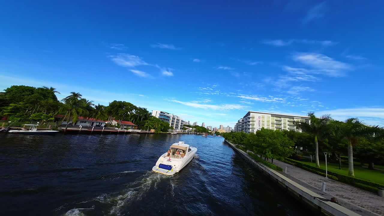 Few cars ride by the concrete bridge. FPV drone flies above the automobiles and then turn to the waterscape flying above the yacht.