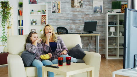 Fröhliche-Mutter-Und-Tochter-Sitzen-Auf-Der-Couch