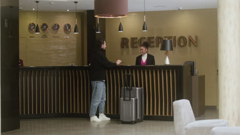 jonge man doet een check-in bij het hotel