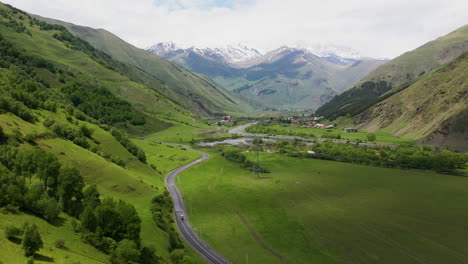 rising drone shot of a road in the caucasus mountains leading to juta georgia