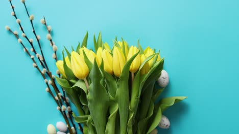 Feiertagsdekoration-Mit-Ostereiern-und-Gelben-Tulpen-über-Blau