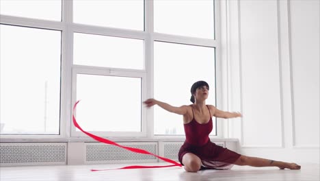 woman performing ribbon dance in a white studio