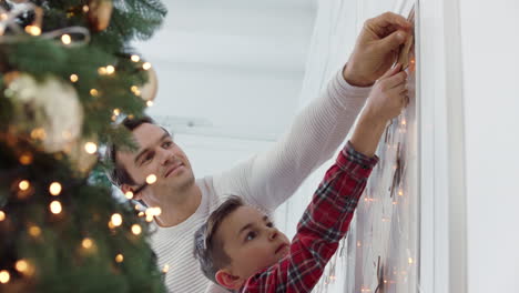 padre guapo decorando la sala de estar con su hijo juntos