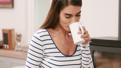 pretty brunette reading newspaper while drinking coffee