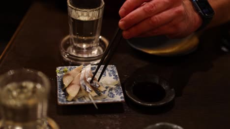 person preparing and serving sashimi slices