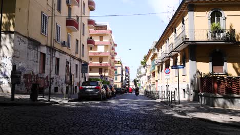 cars driving through a cobblestone street