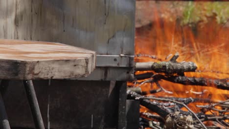 caldero tradicional para hacer queso italiano al fuego hecho con madera con una tabla de cortar con leche escurrida del queso recién hecho