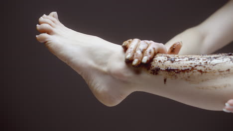 woman applying coffee scrub to her leg