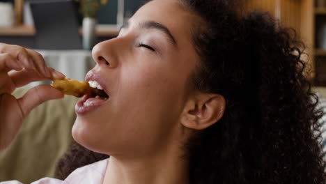 close-up of a woman savoring a snack with closed eyes