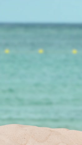 video concepto de vacaciones de verano vertical con la pala del niño en la playa de arena contra el fondo del mar