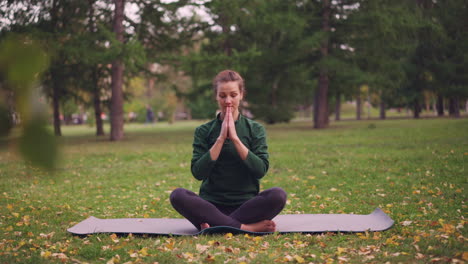 woman meditating outdoors in a park