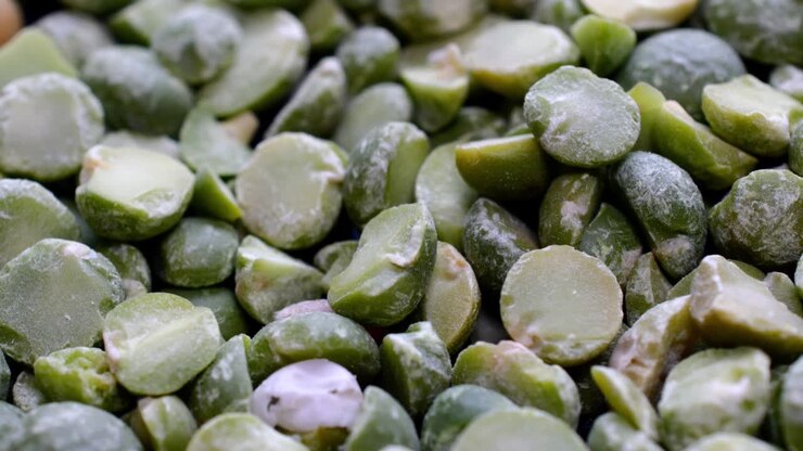 Pile of dried split green peas rotate slowly on turntable.