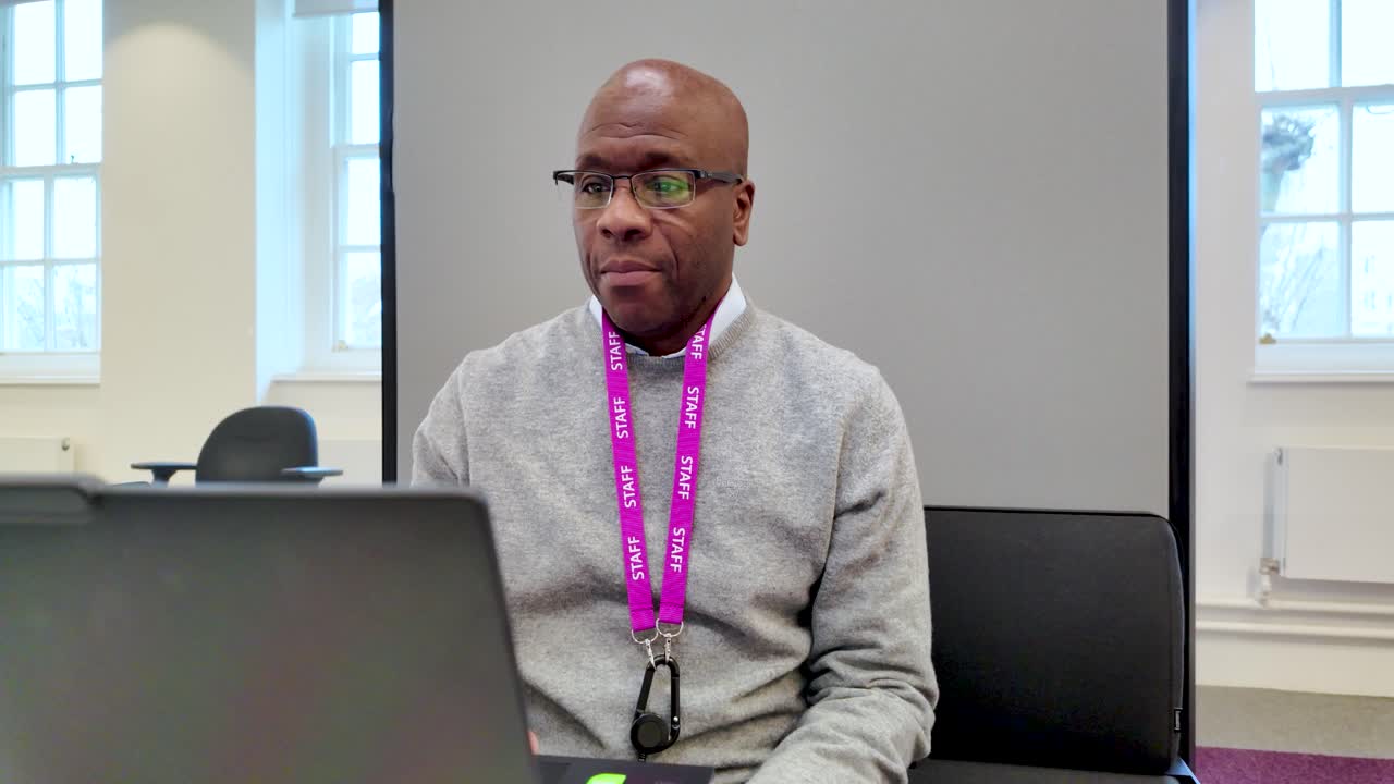 Serious professional man leading a webinar in a modern enclosed office space.