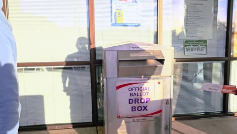 Man-Votes-in-Election-by-Casting-Mail-in-Ballot-Letter-in-Slot-at-Voting-Booth-with-Offical-Ballot-Drop-Box-Sign-for-Democratic-Government-Campaign-in-Presidential-Race