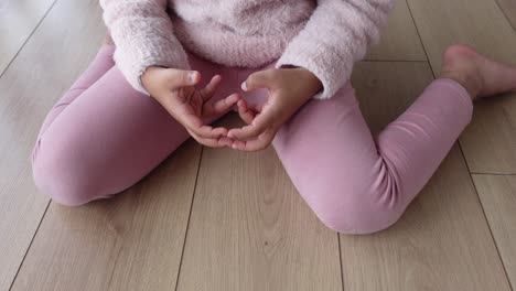 niño sentado en el suelo con ropa rosa