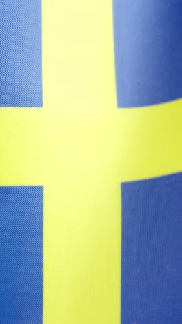 vertical video of swedish national flag waving by the wind