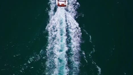 high-angle aerial footage captures a sleek yacht cutting through the ocean, leaving a trail of white wake, perfect for marine adventure themes and luxury lifestyle visuals