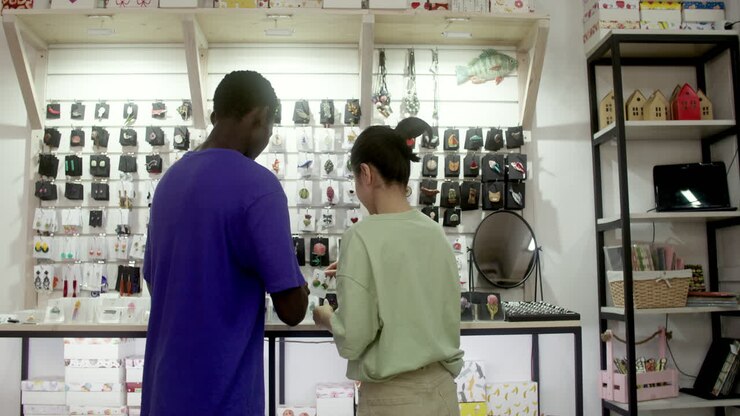 Back view of young man and saleswoman in a store
