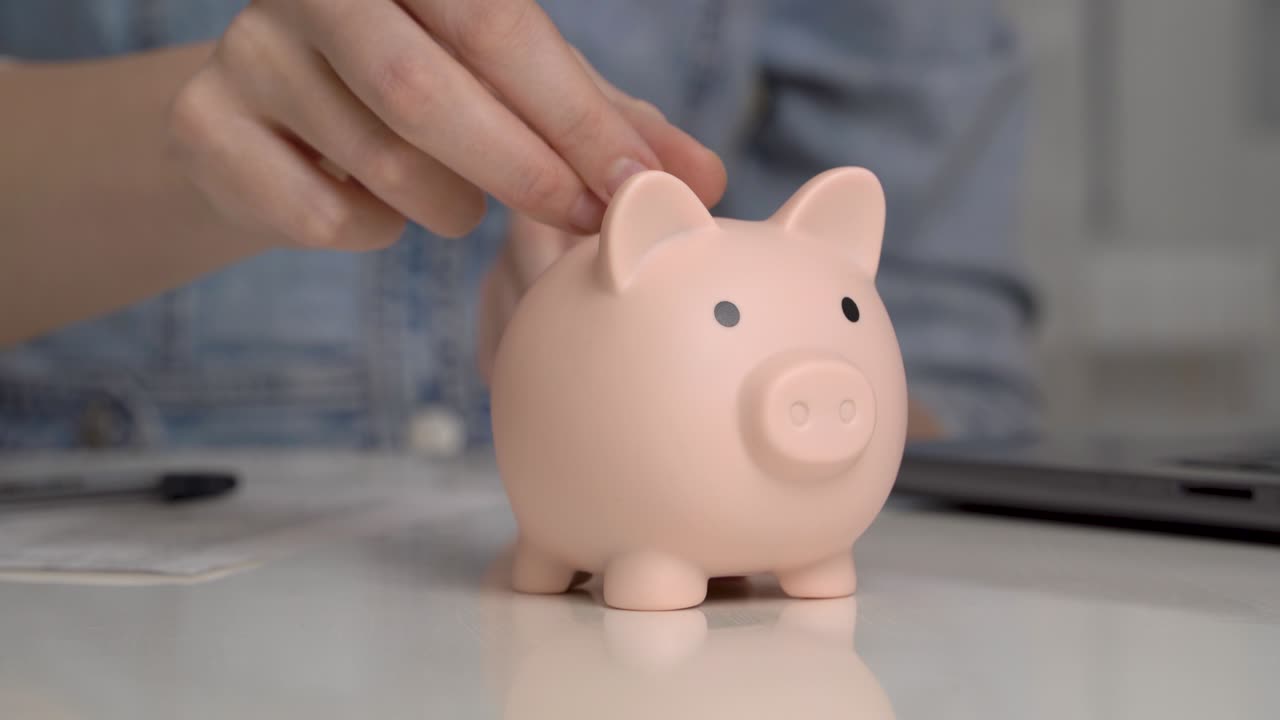 la mano de la mujer pone monedas en una alcancía. concepto de ahorro de dinero