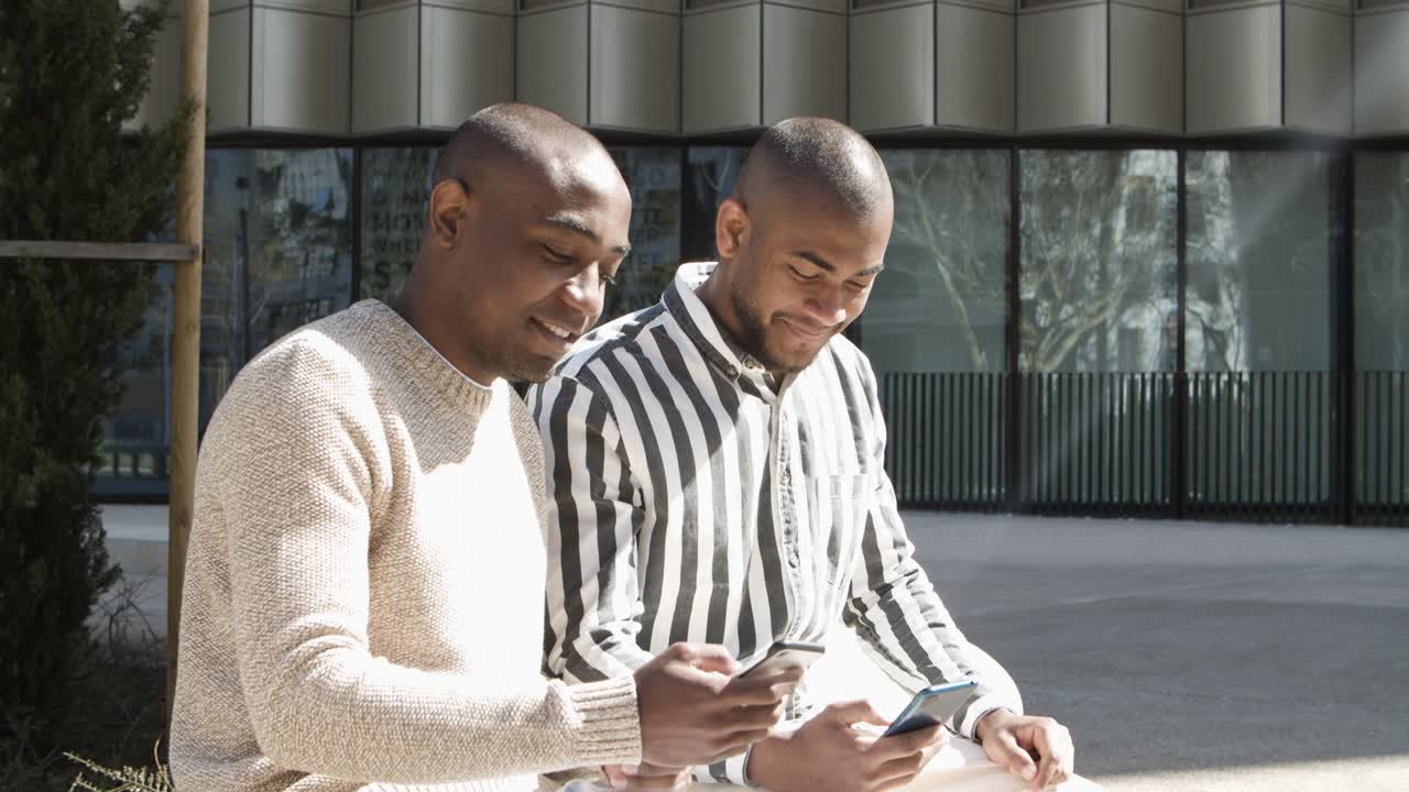 Cheerful friends talking and using phones