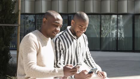 Cheerful-friends-talking-and-using-phones