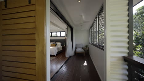 barn door, outdoor wooden deck into contemporary modern styled bedroom with wooden floor boards