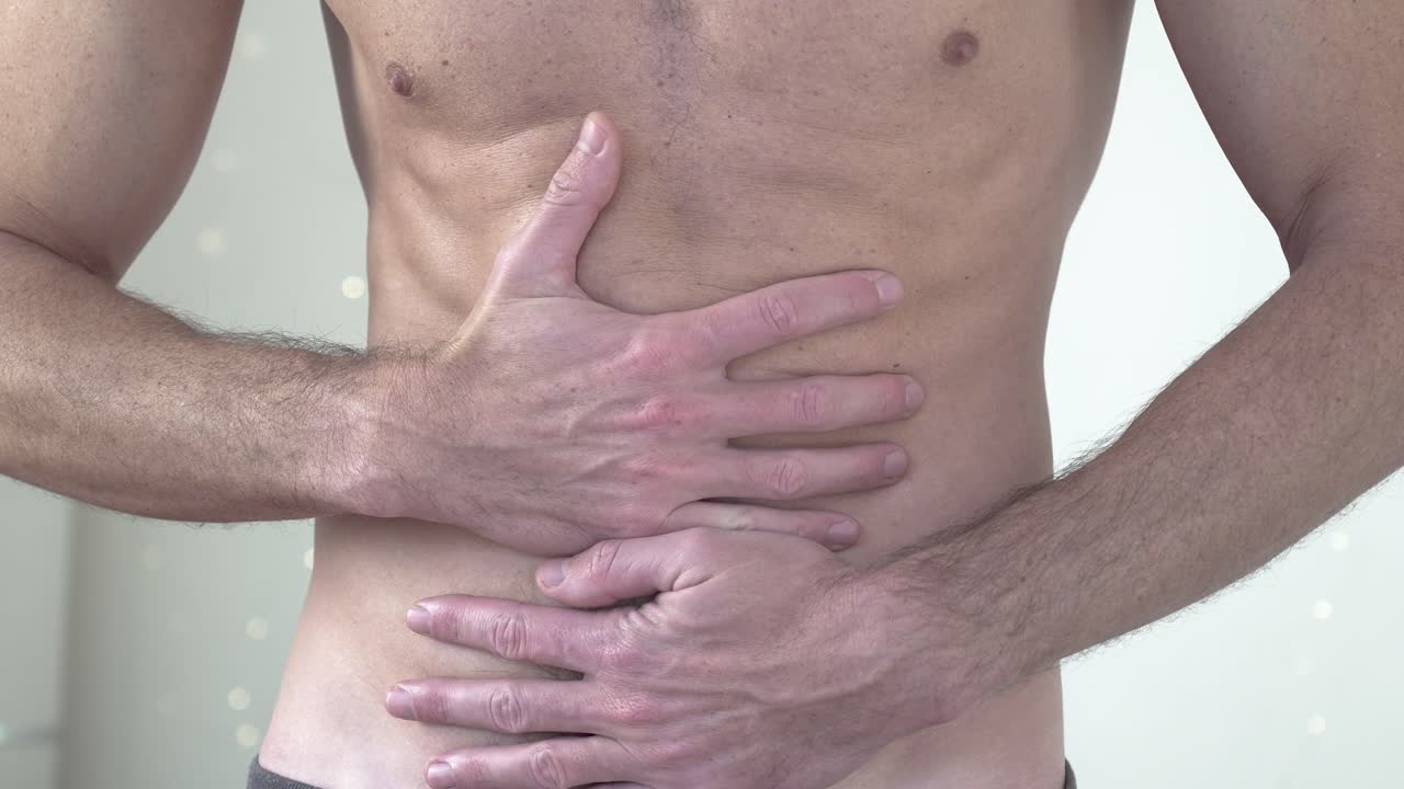 fotografía de cerca de un hombre musculoso con calambres y dolores estomacales