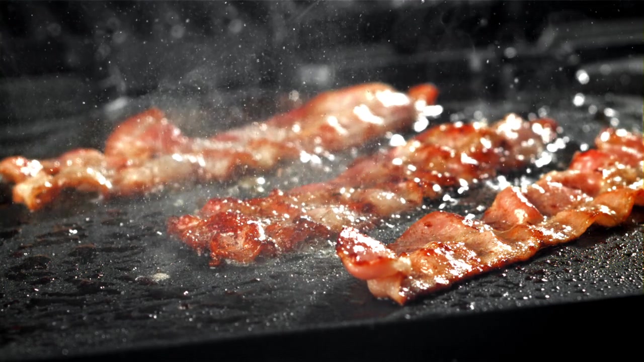 Pancetta croccante che sfrigola su una padella calda